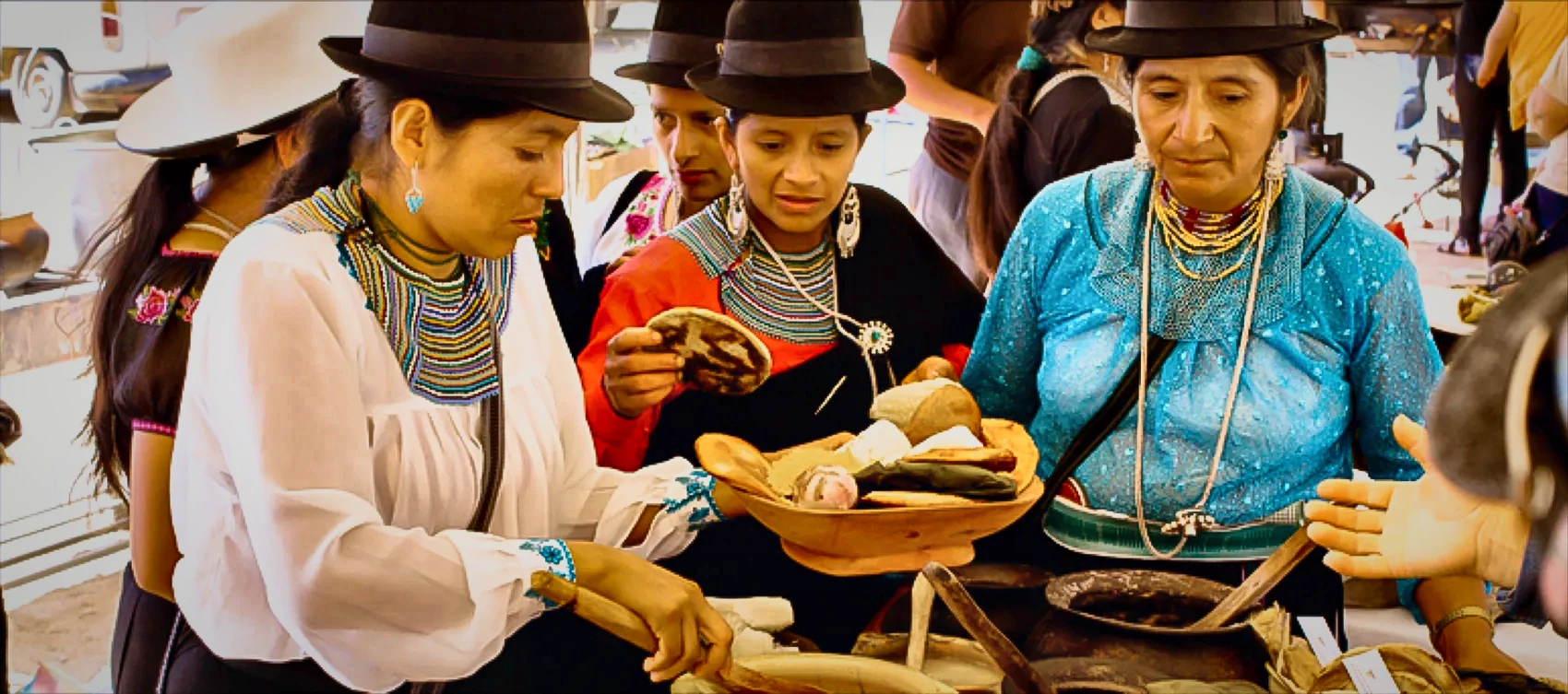 Saraguro women in traditional dress and beaded collares de mullos necklaces at a community gathering