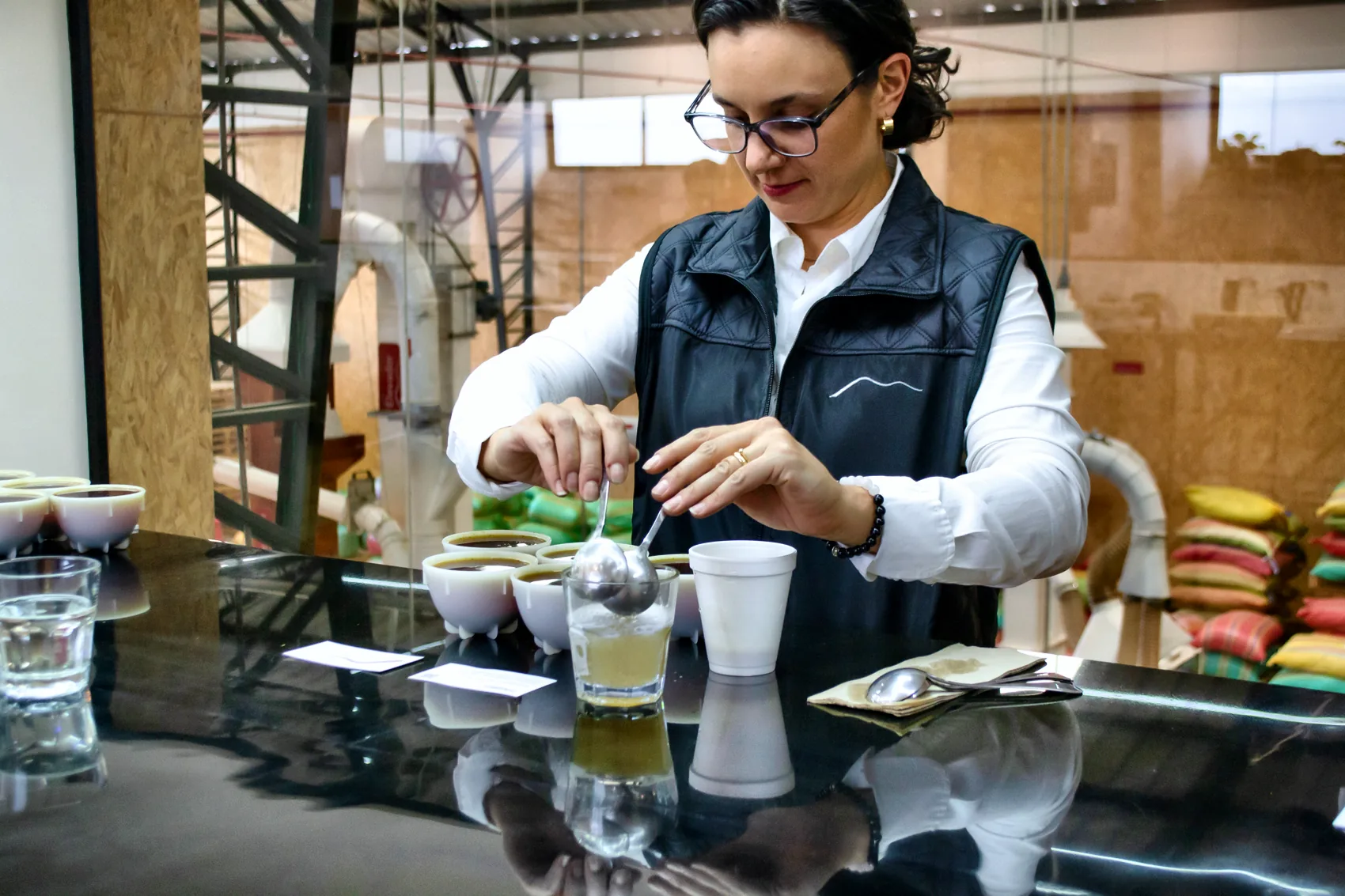 A CafExporto Q-grader setting cups on the cupping table in the Cuenca lab